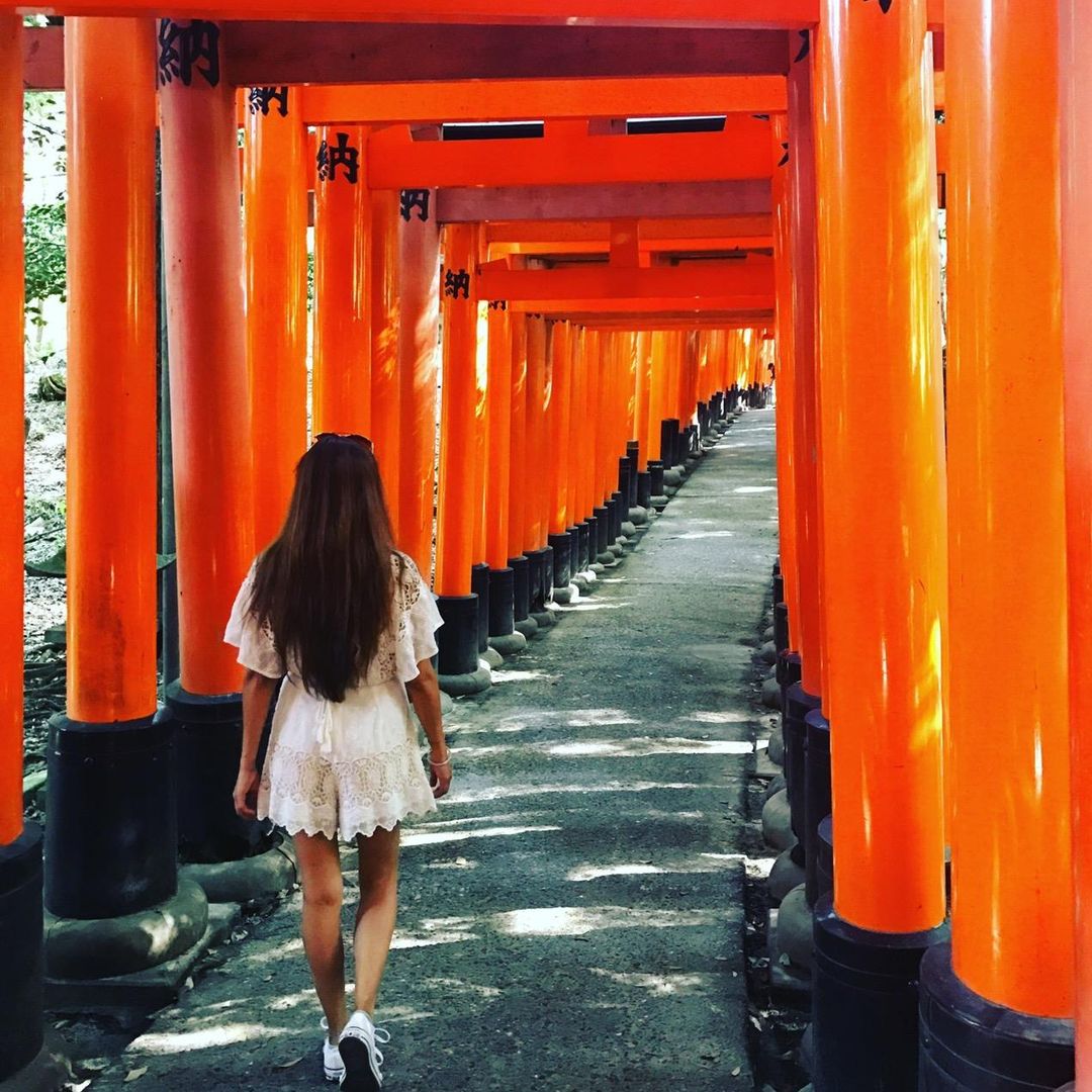 Magaly walking through the torii gate pathway at Fushimi Inari, Japan